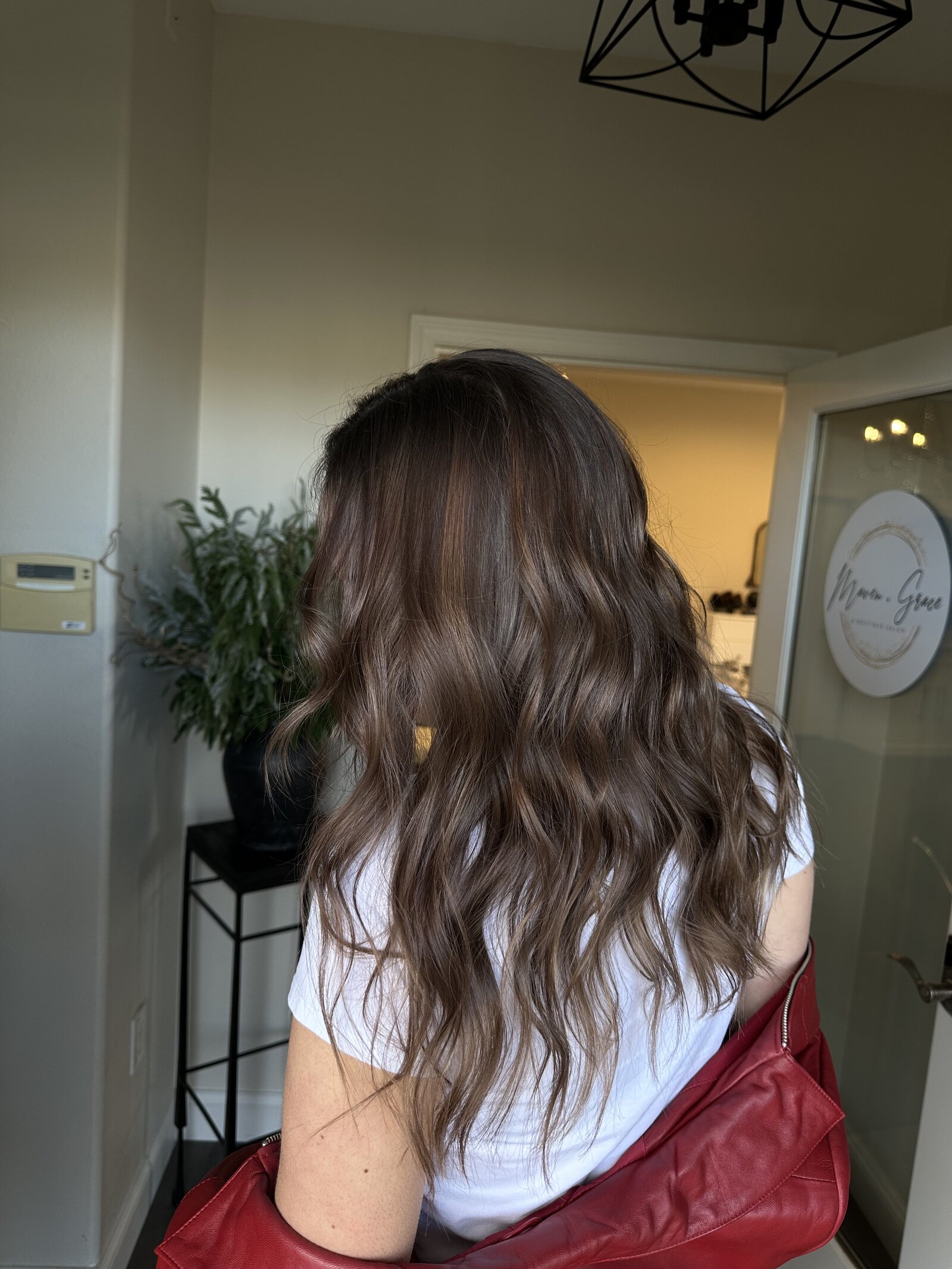 Dimensional brunette with soft waves—representing custom color and lived-in looks at Maven + Grace.”