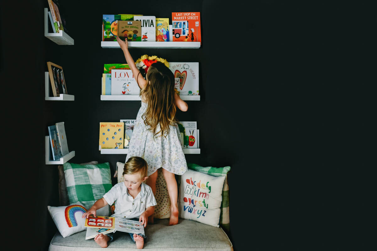 kids getting books down off a book shelf