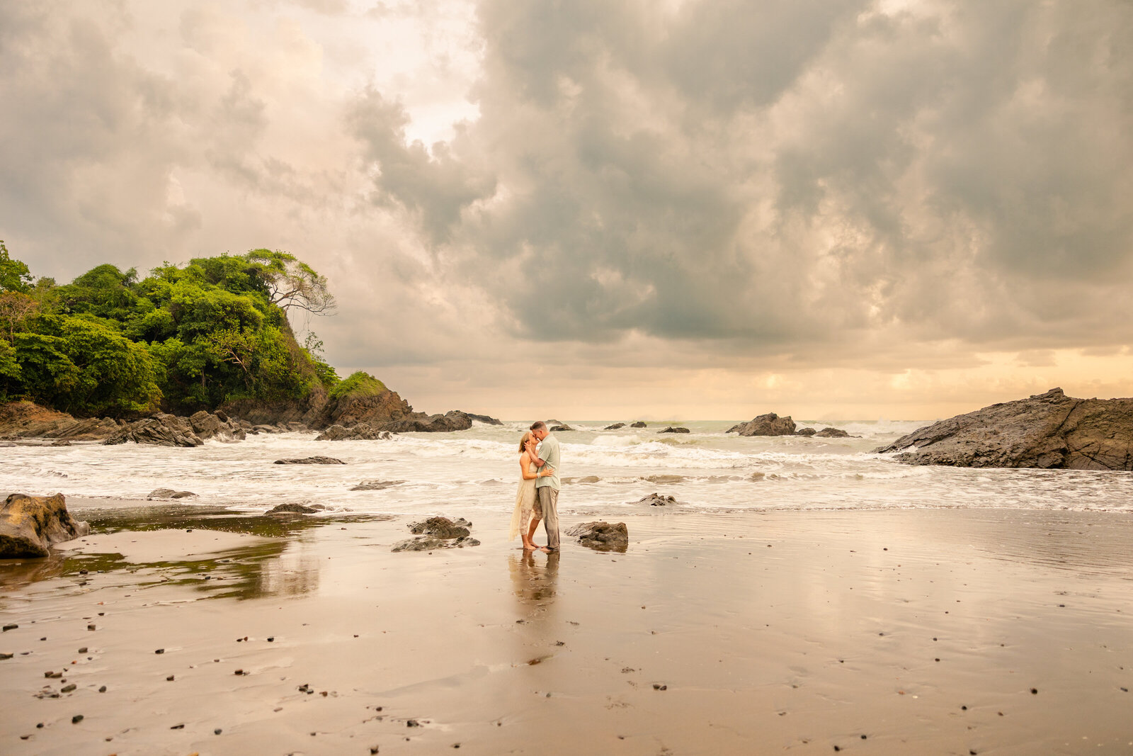 Couple embraces on scenic rugged rustic beach coastline