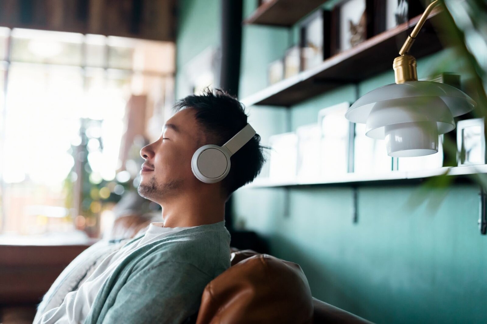 asian man listening to a guided hypnosis wearing headphones