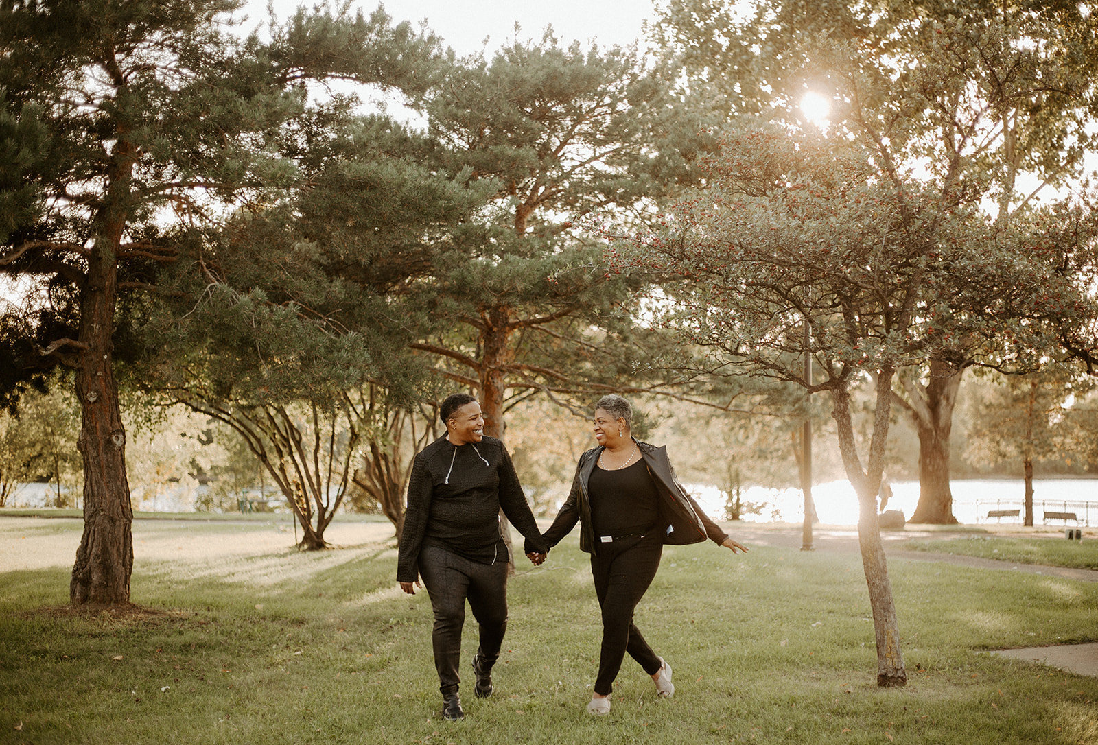 Couple holding hands walking in a park during their Minneapolis Engagement session