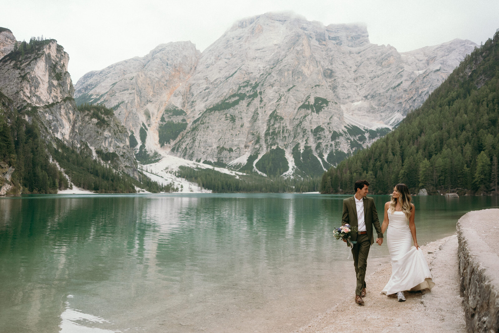 Couple exchanging vows at the stunning Lago di Braies, surrounded by the Dolomites’ natural beauty on their wedding day.