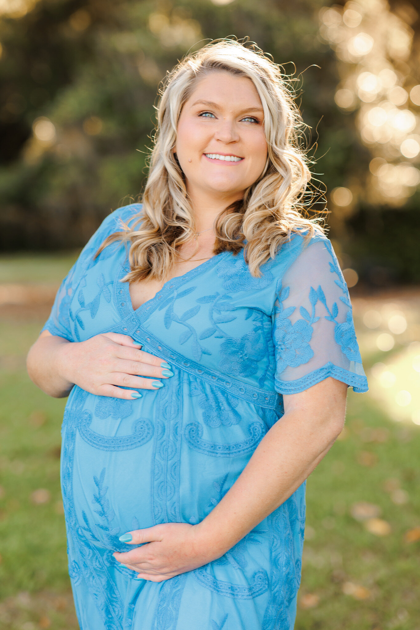 Young mom holding belly during maternity photoshoot at holly oak on the marsh in Savannah, ga