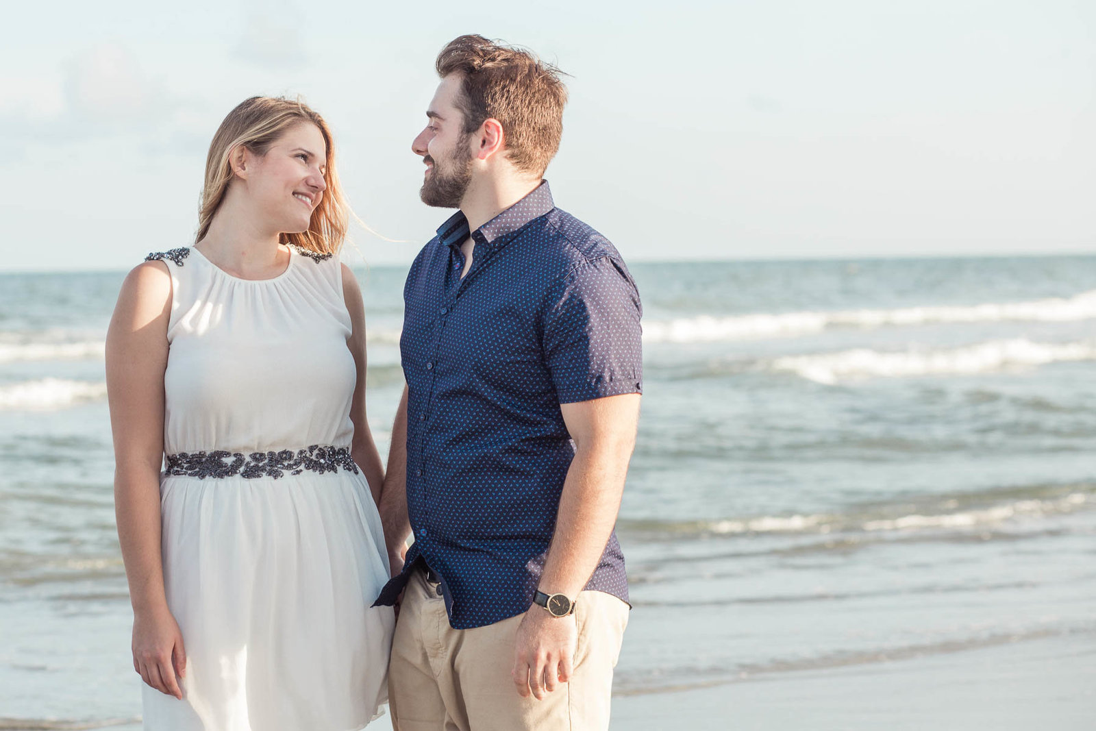 Engaged Couple walking along shore, Folly beach in Charleston, South Carolina