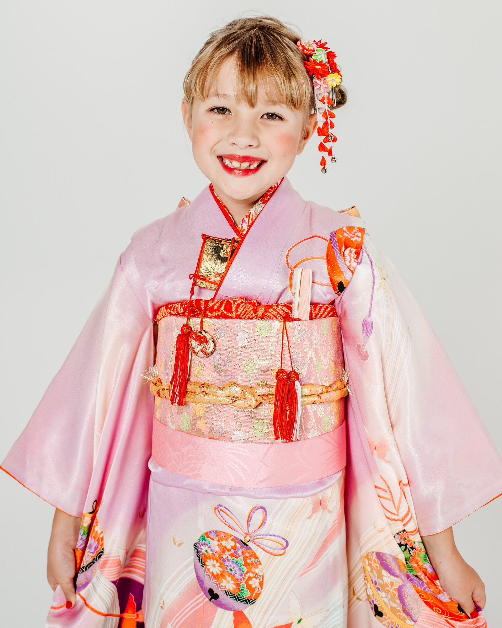 Young girl in pink kimono smiling for Shichi-Go-San portrait | 七五三 女の子 ピンクの着物 スタジオ撮影