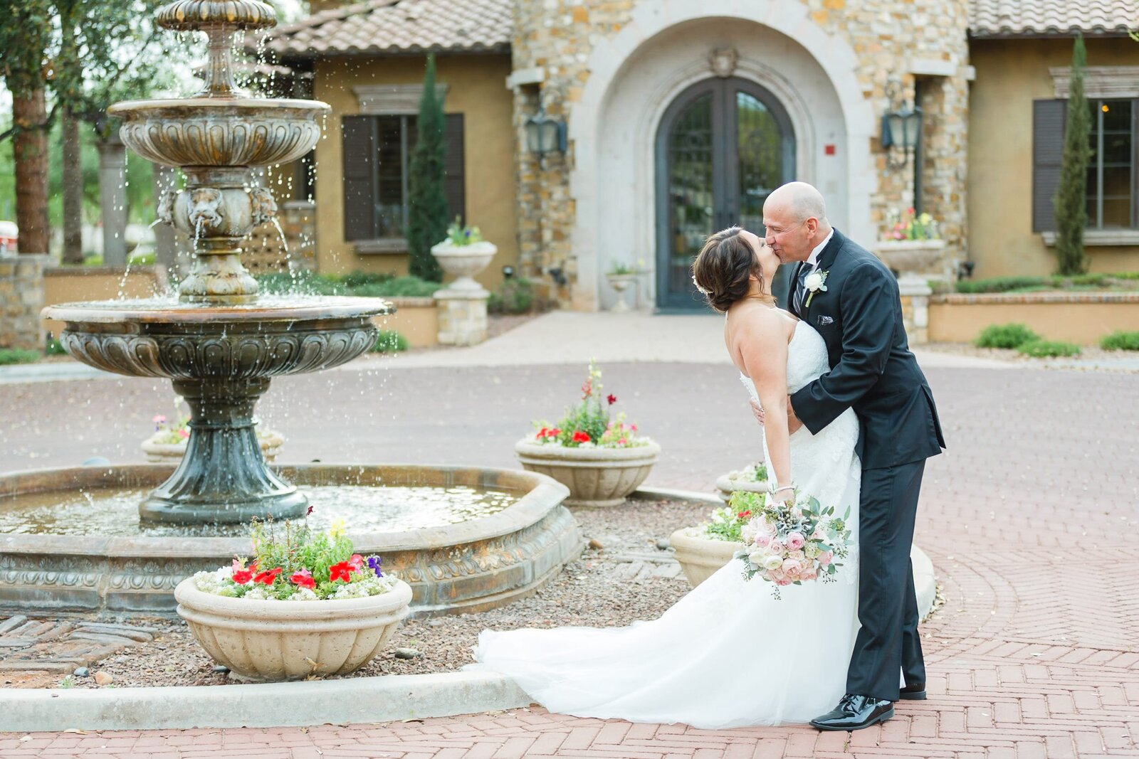 bride-groom-kissing-by-villa-siena-fountain