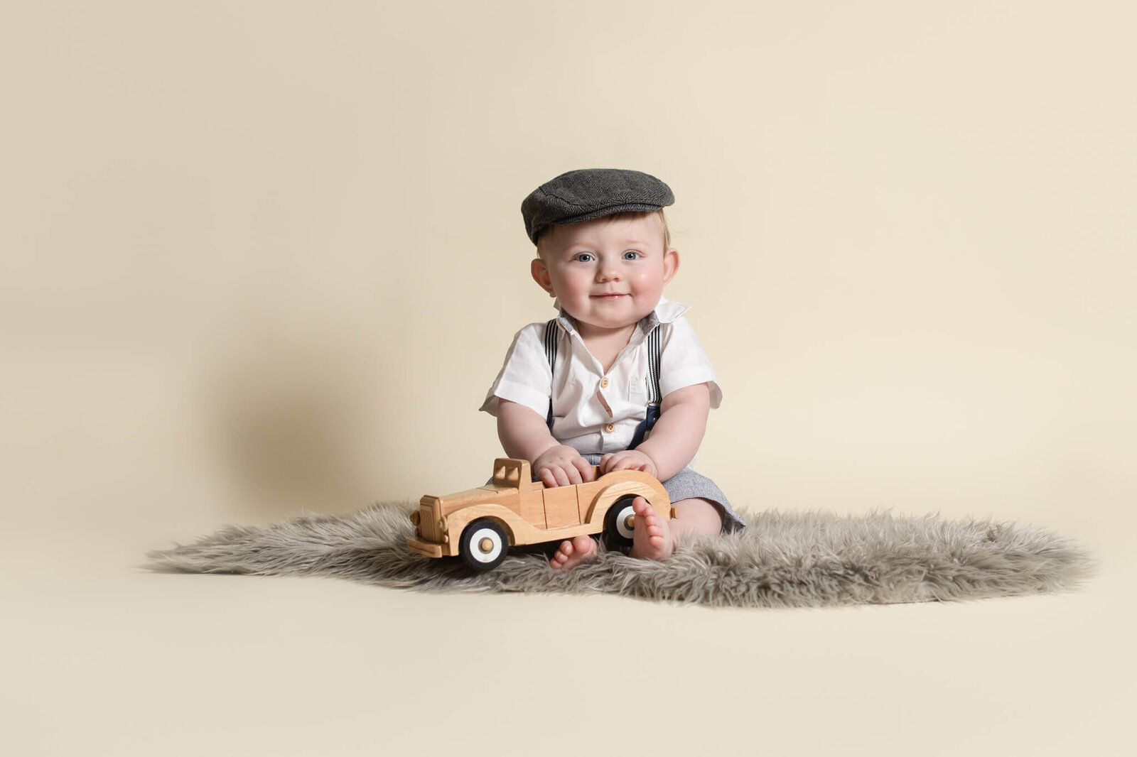 Six month sitter session of little boy wearing short sleeved suit set and scaly cap