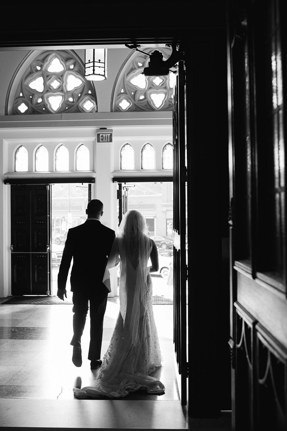 bride and groom exit church from behind silouhette