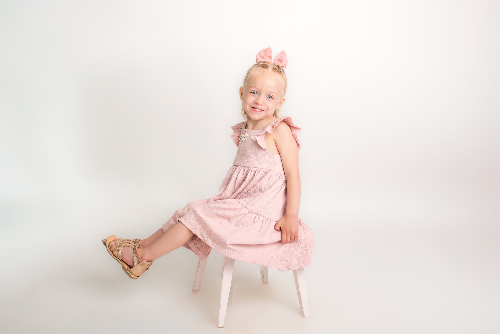 young girl sits on stool for modern indoor school picture