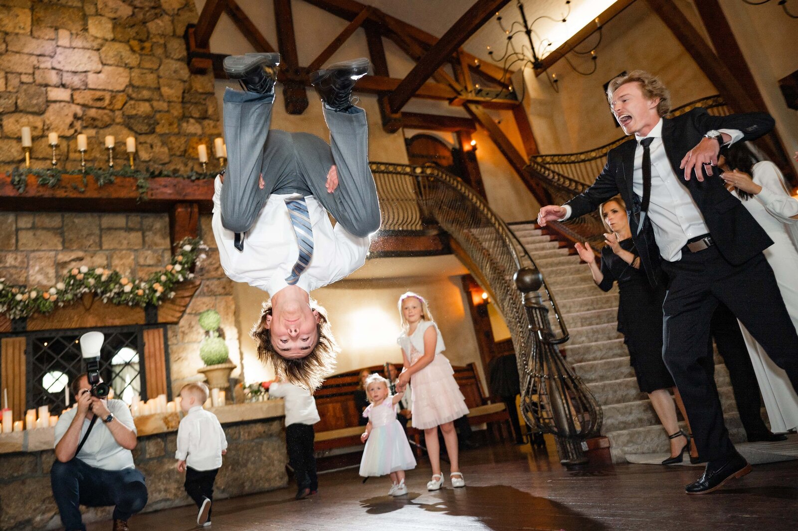 Dancing at wedding reception as guest does a backflip.