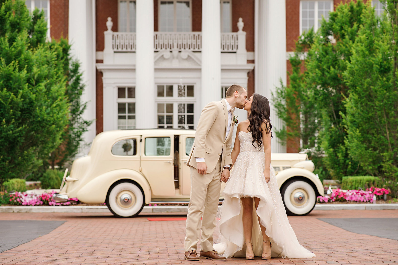 Bride and groom kissing in front of the Bourne Mansion