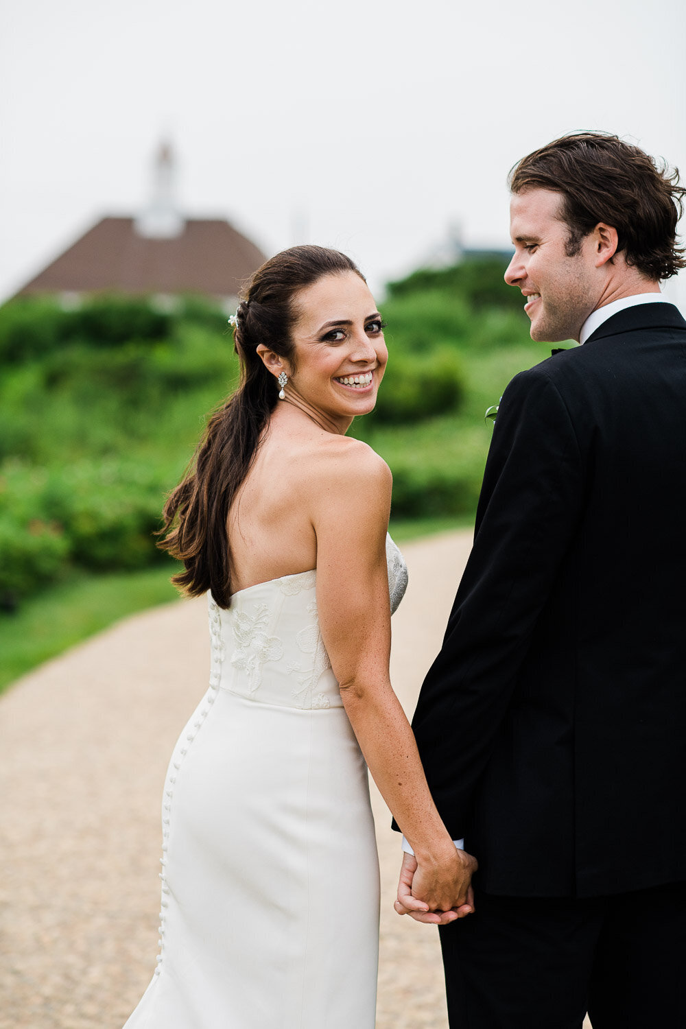 bride looking back walking holding hands with groom