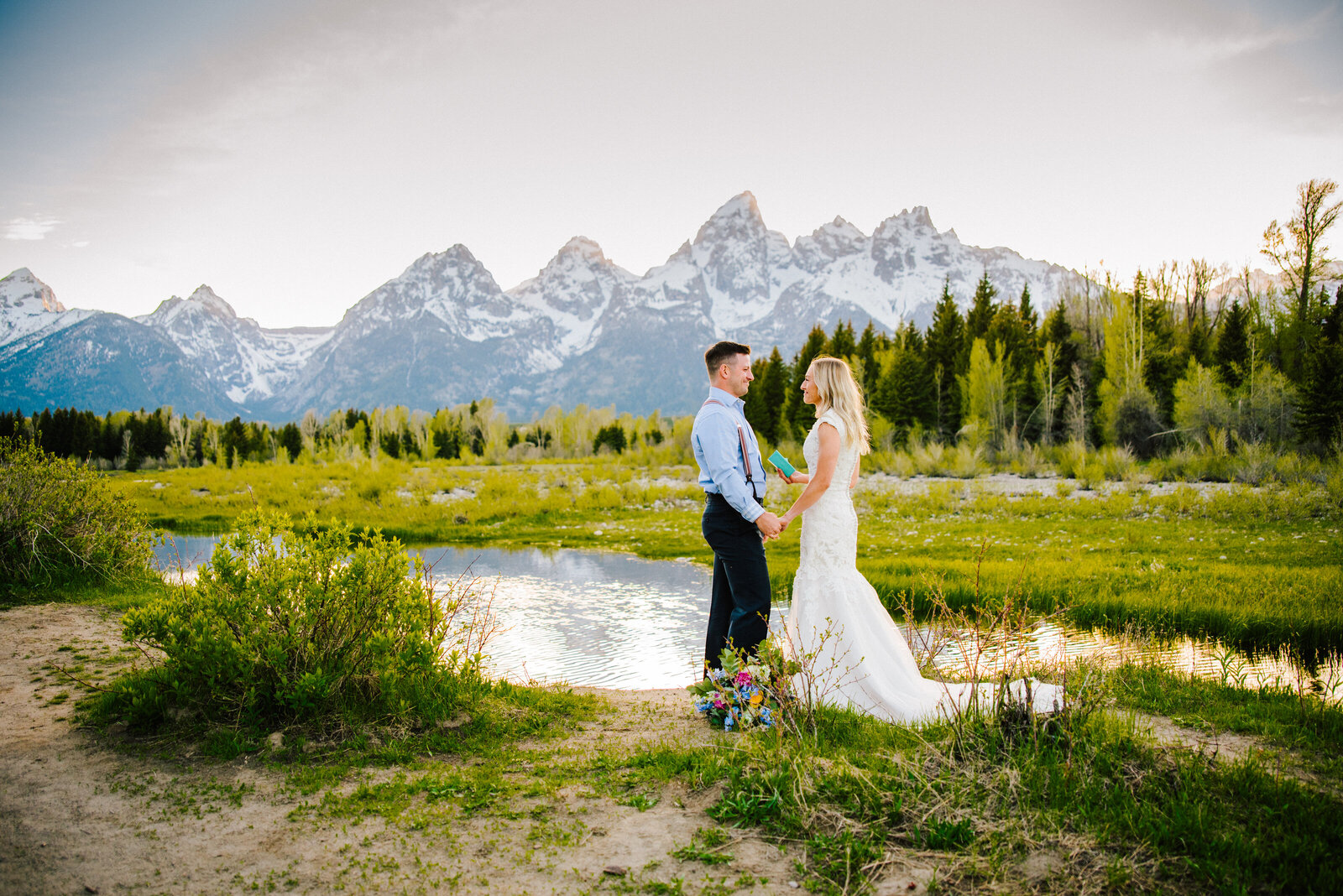 bride and groom hold hands while they exchange vows at Schwabacher Landing