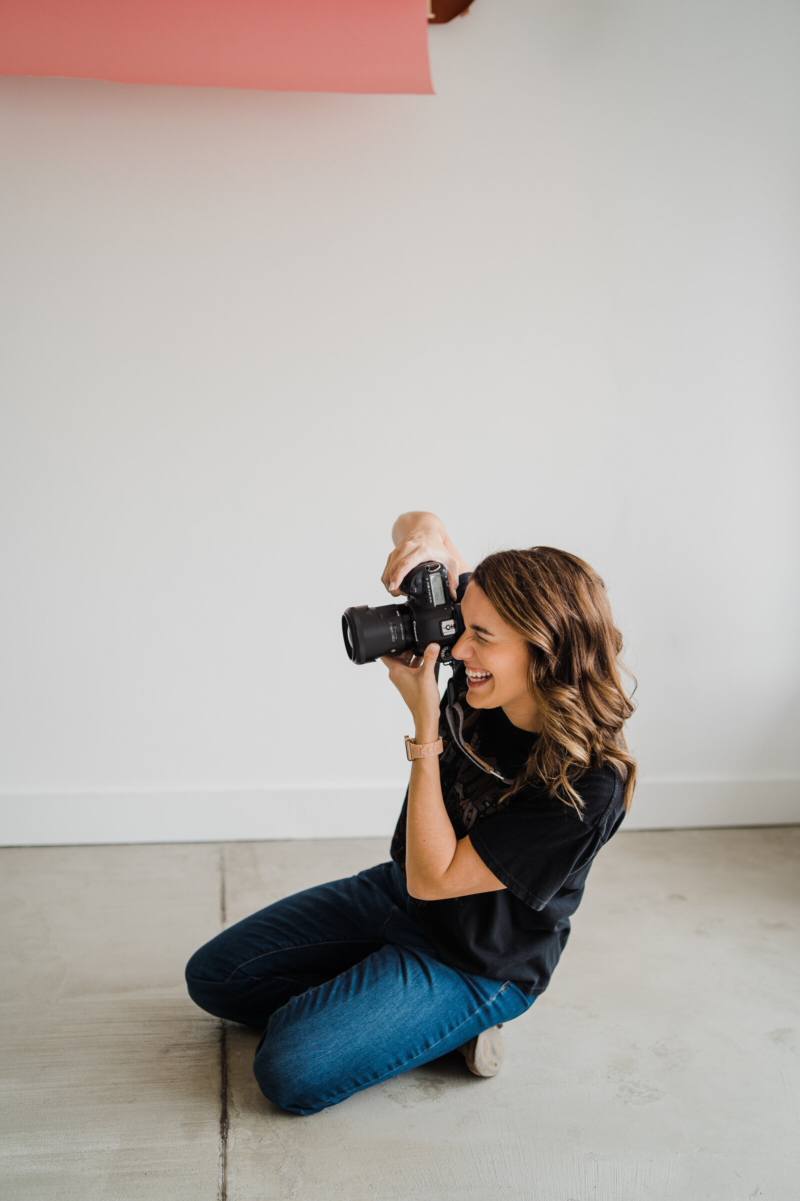 Photographer in studio working holding camera