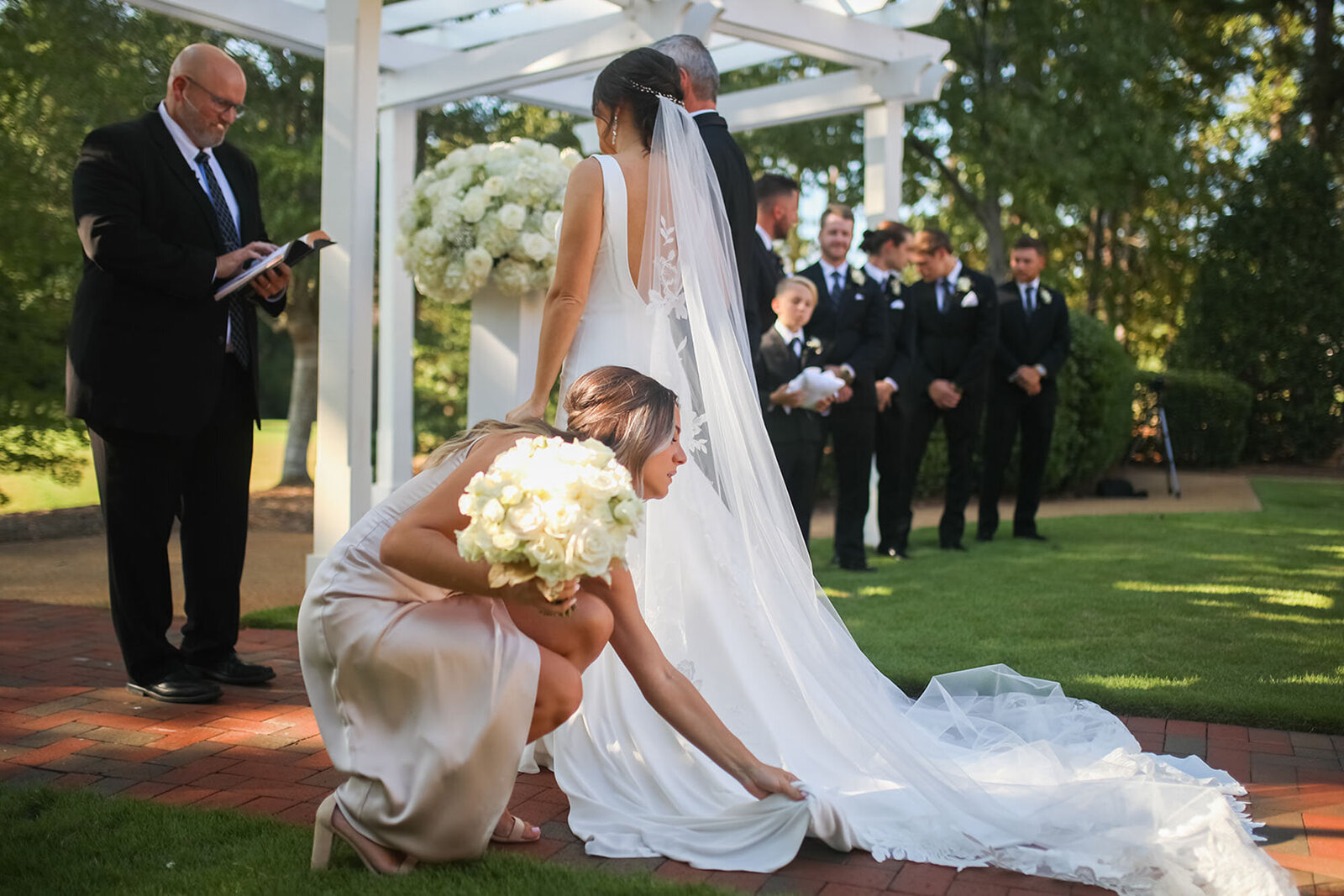 Maid of honor fixing bride dress outside at North Carolina destination wedding