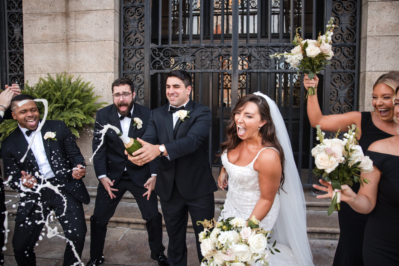 bridal party sprays champagne at boston public library