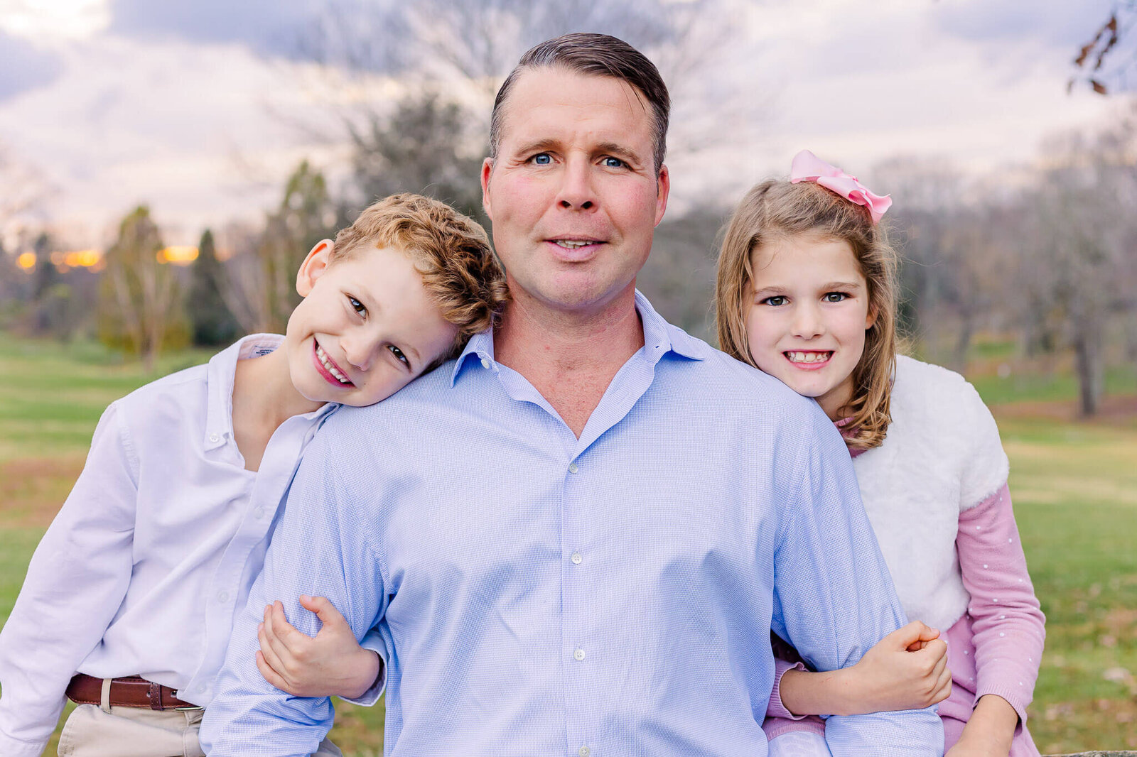 A dad and his two children smiling for Burke family photographer, Melissa Driggers.