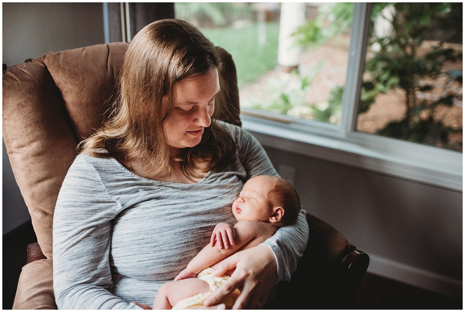 mom cradling newborn baby boy in front of window Emily Ann Photography Seattle Photographer