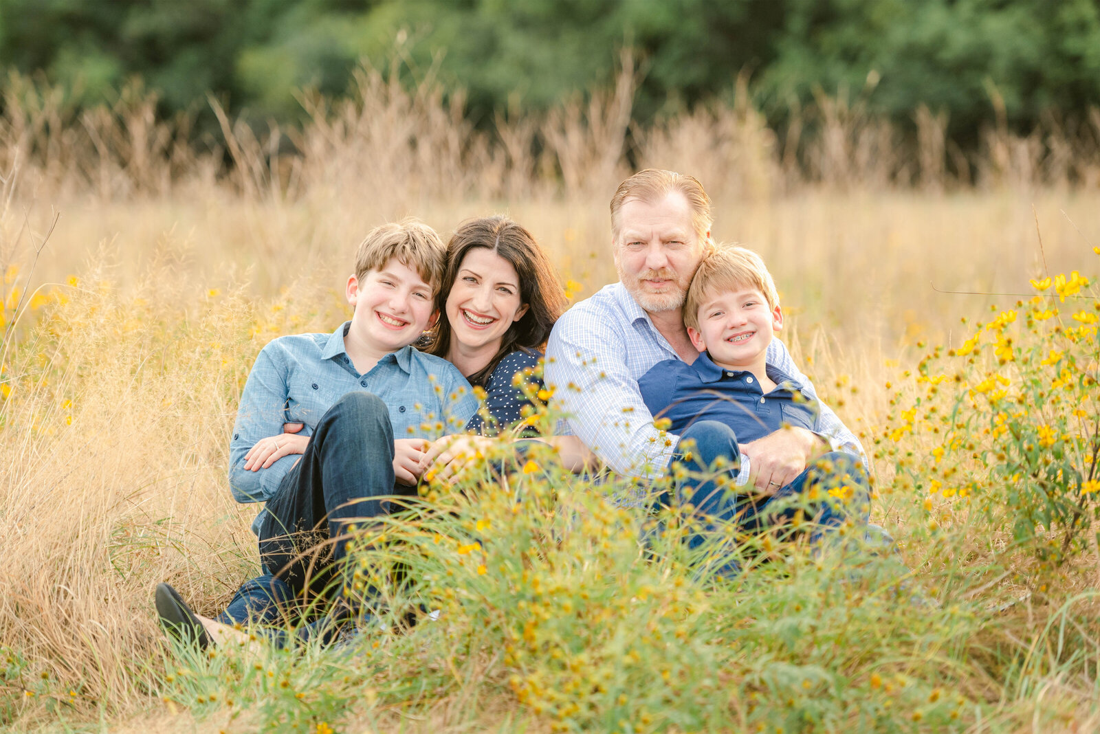 Family of four in a meadow getting fall family photos down by Chicago Family Photographer Kristen Hazelton