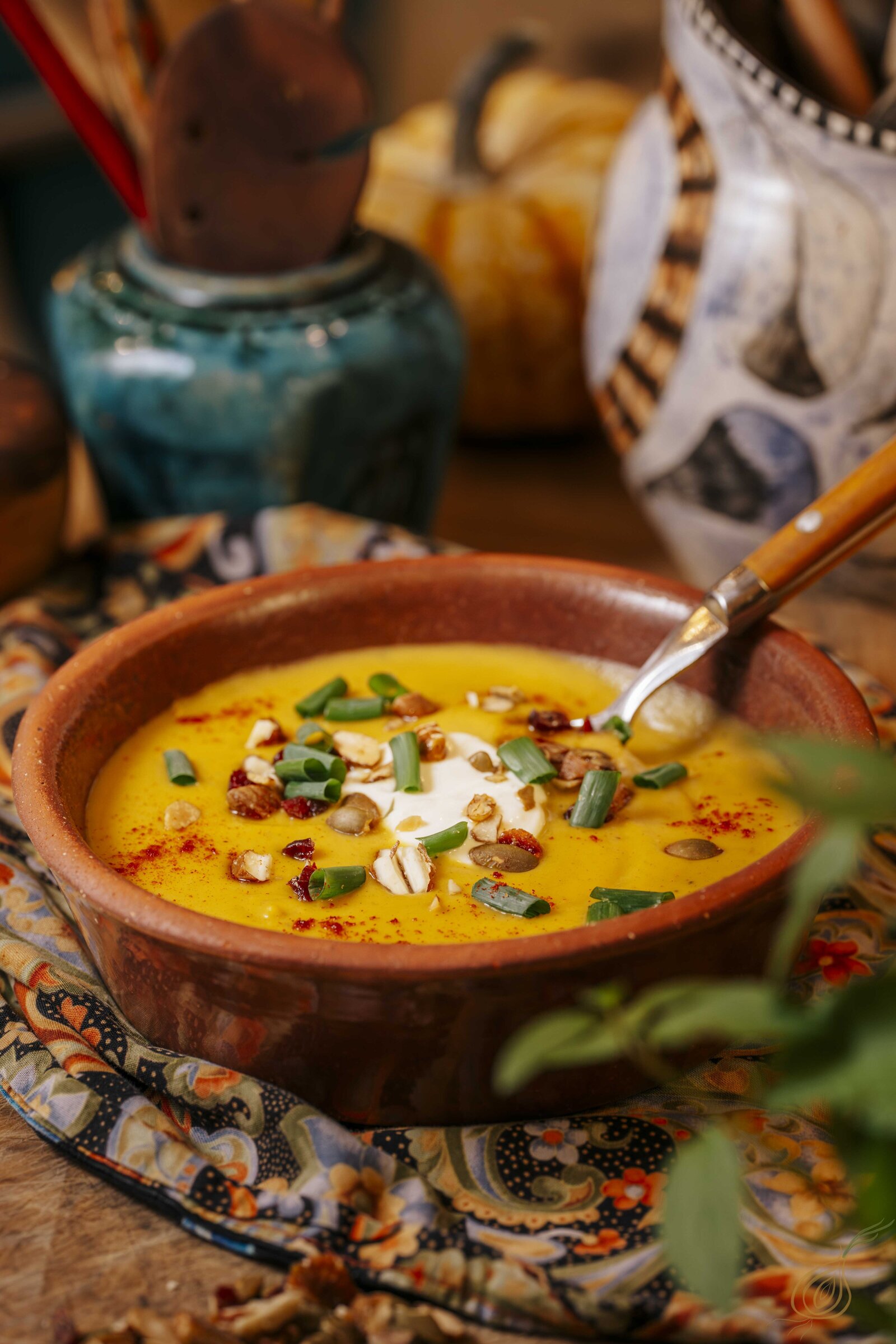 A bowl of soup with a spoon on top, set on a table, exuding warmth and comfort.