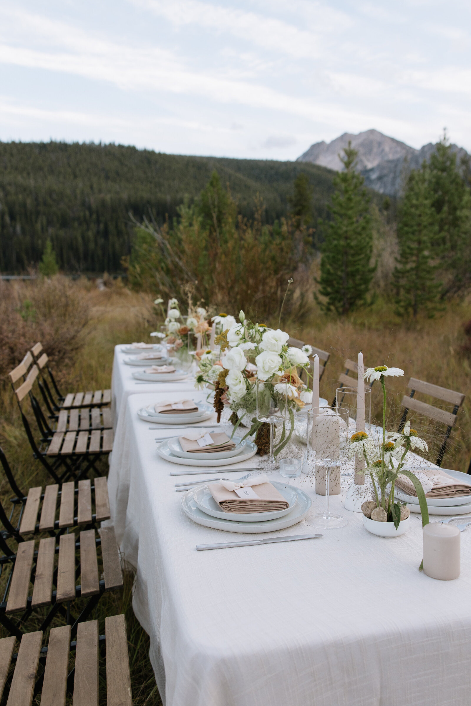 Reception details with wood tables and floral centerpieces at intimate wedding in Stanley, Idaho