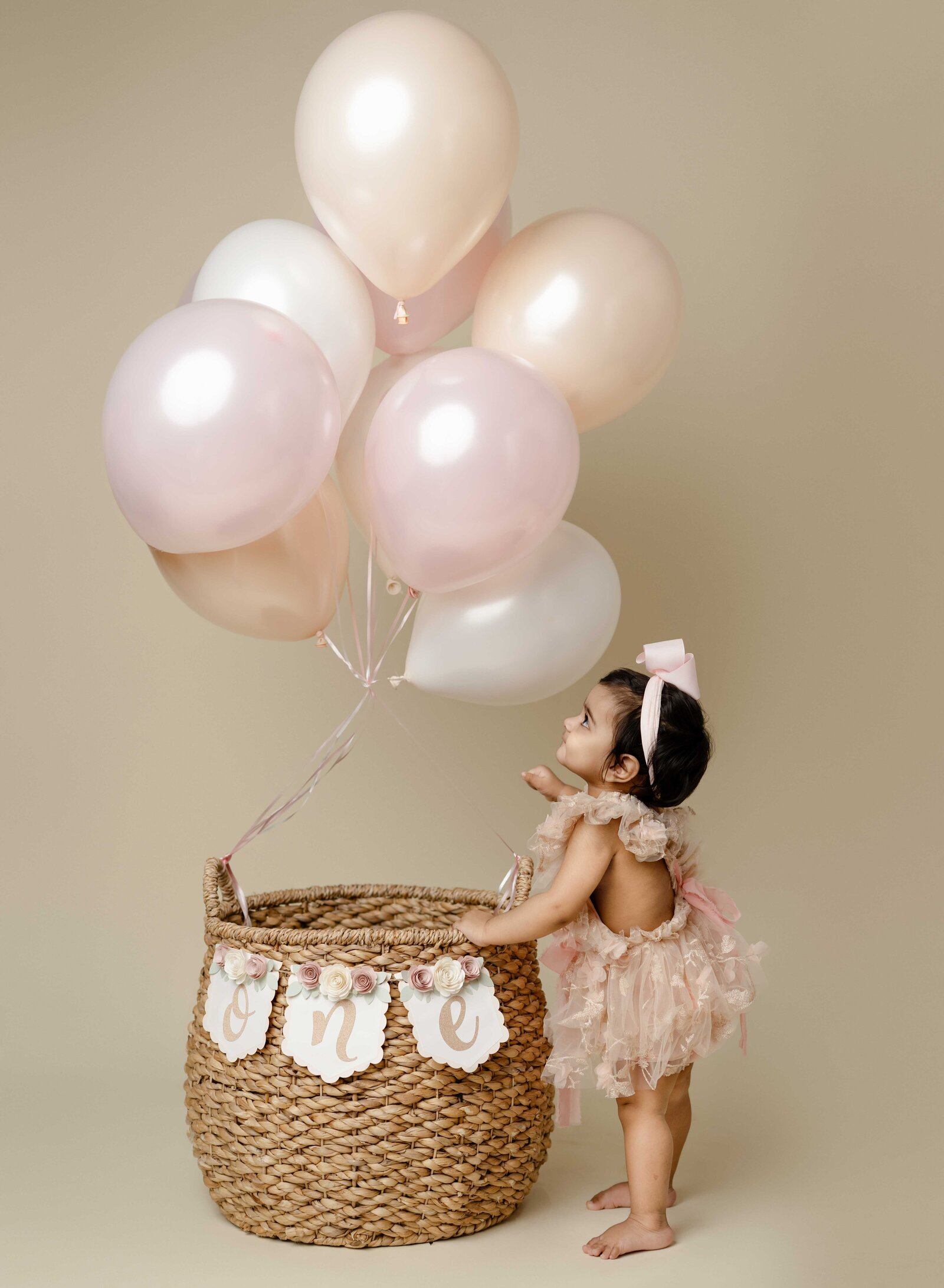 Baby girl looking up at balloons. Cake Smash photo taken by Jenni Nikki in Atlanta, GA