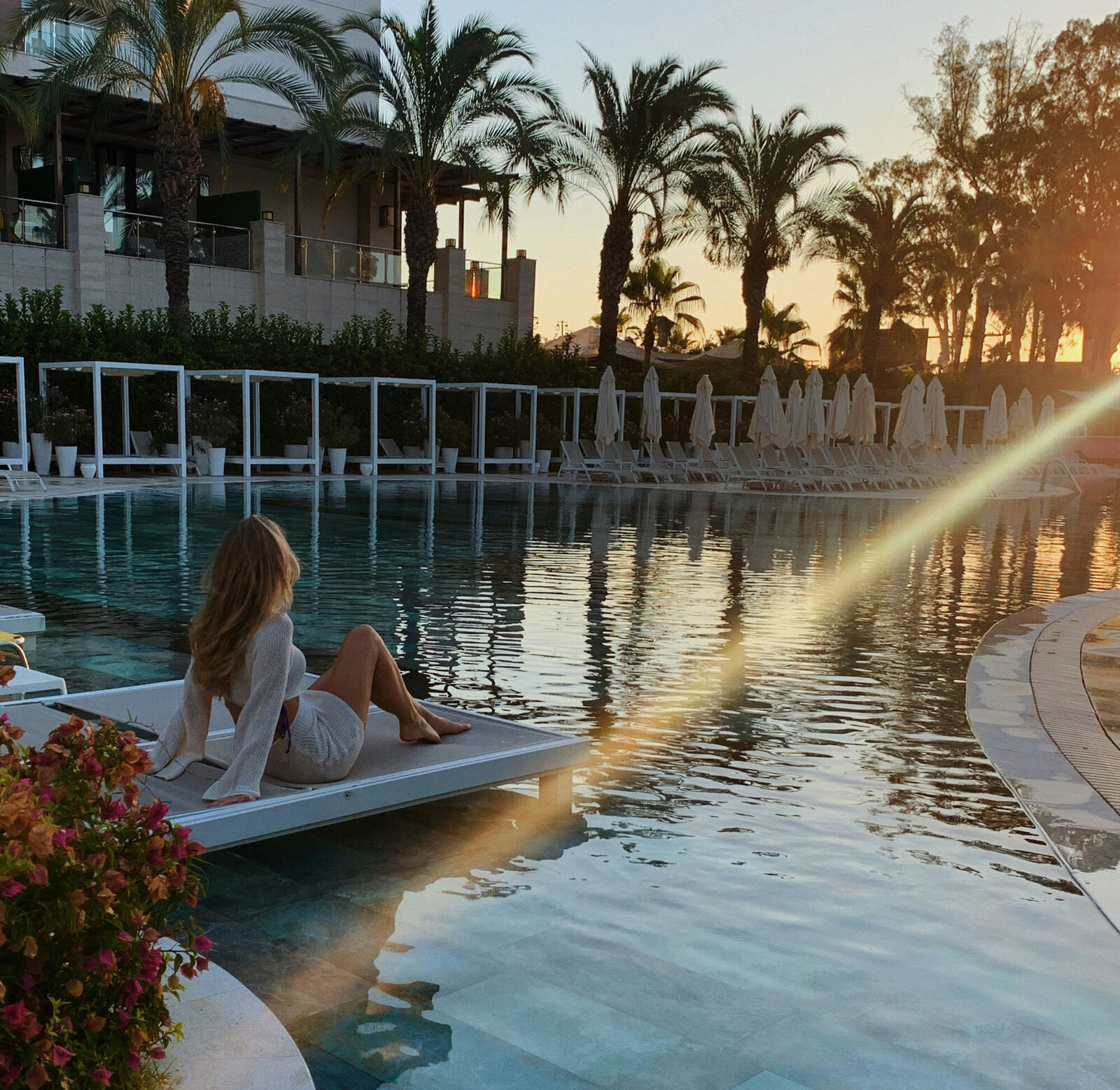 Woman sits on the edge of a swimming pool