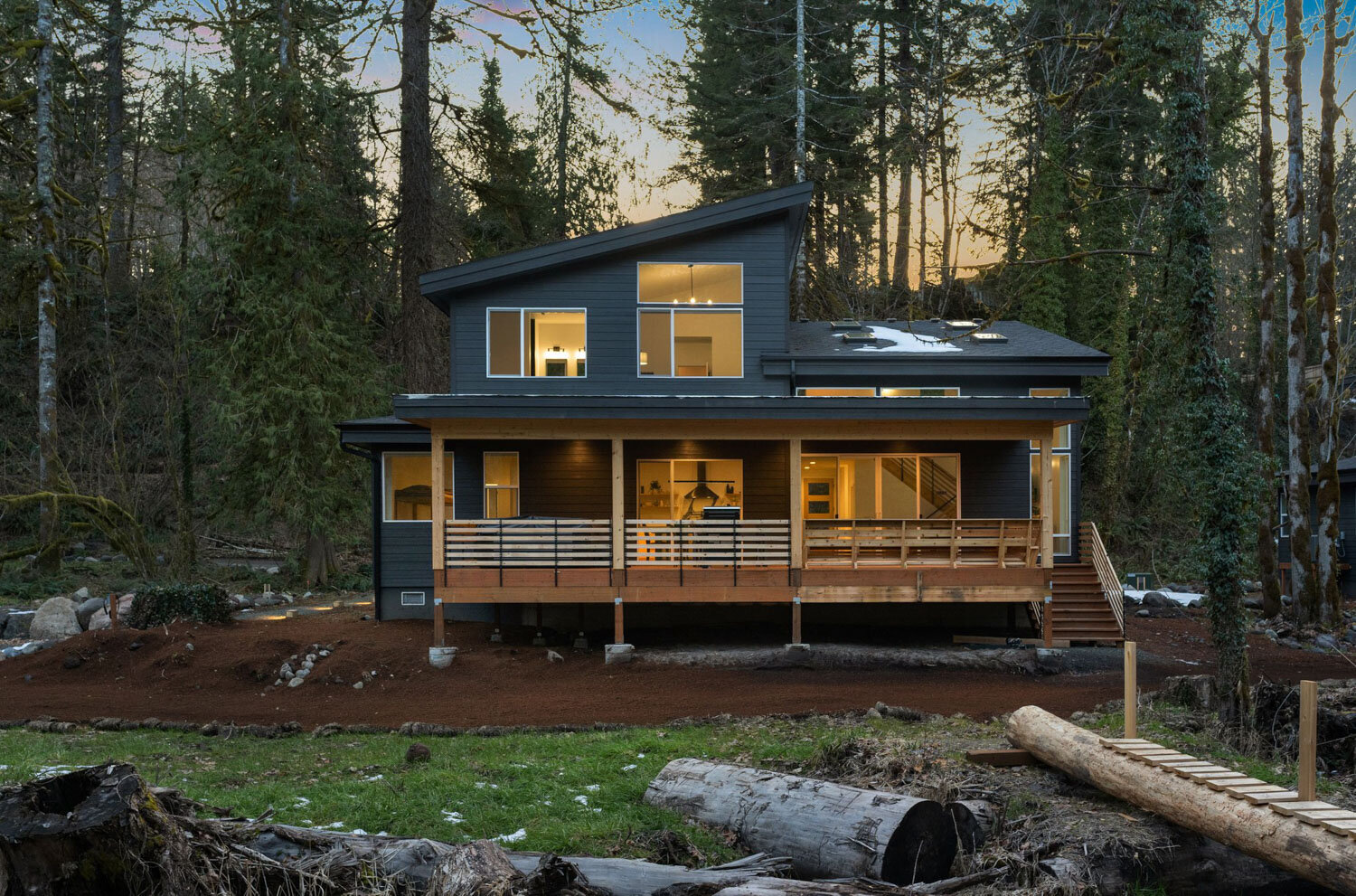Modern black cabin with large windows and wooden porch