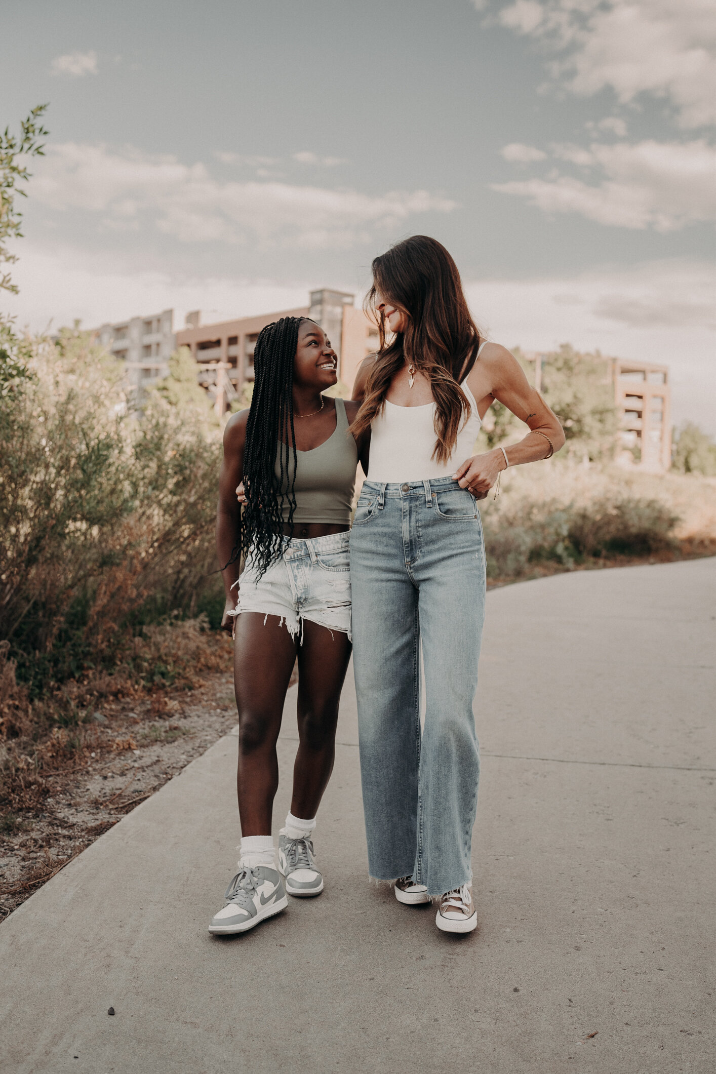 A white mom put her arm around her black daughter as they walk on a trail during a sunrise session in Colorado.