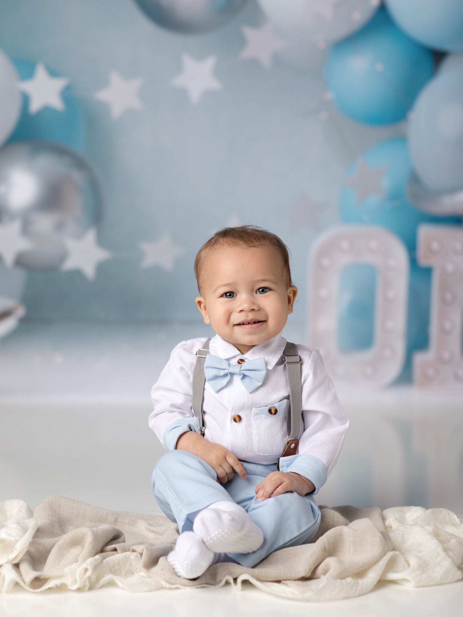 one year old boy posing for first birthday photoshoot