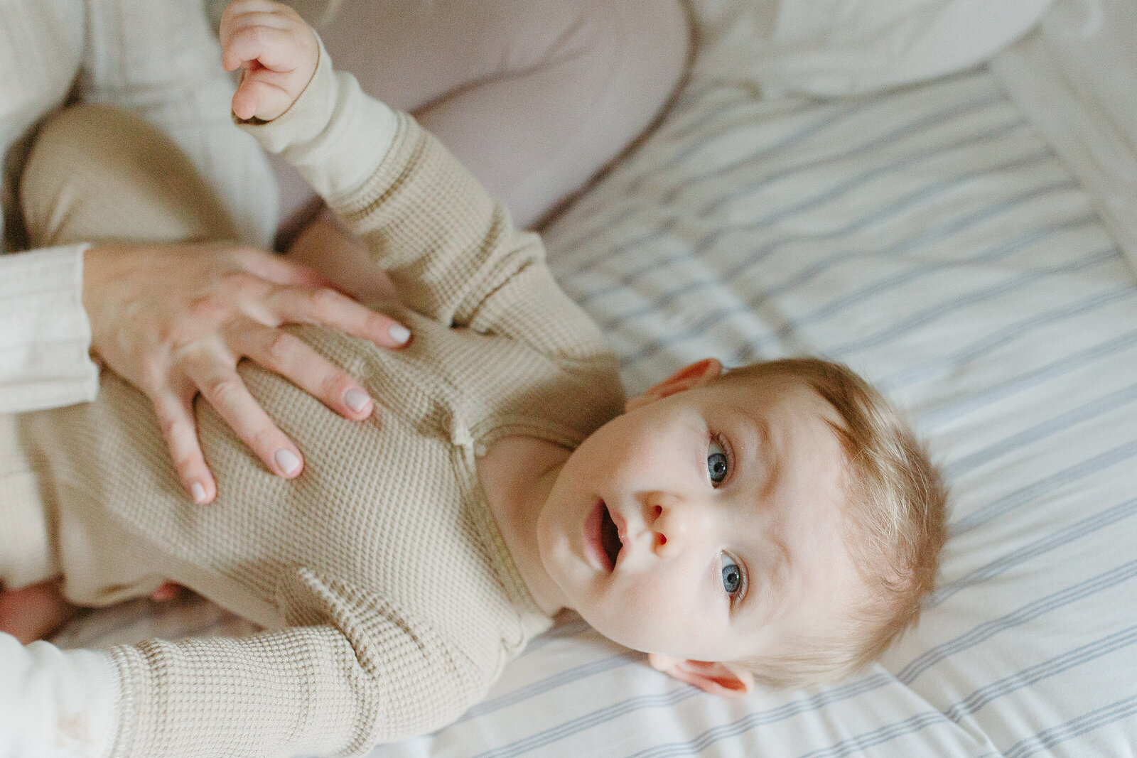 Closeup of baby boy laying in bed in a Portland, Oregon home.