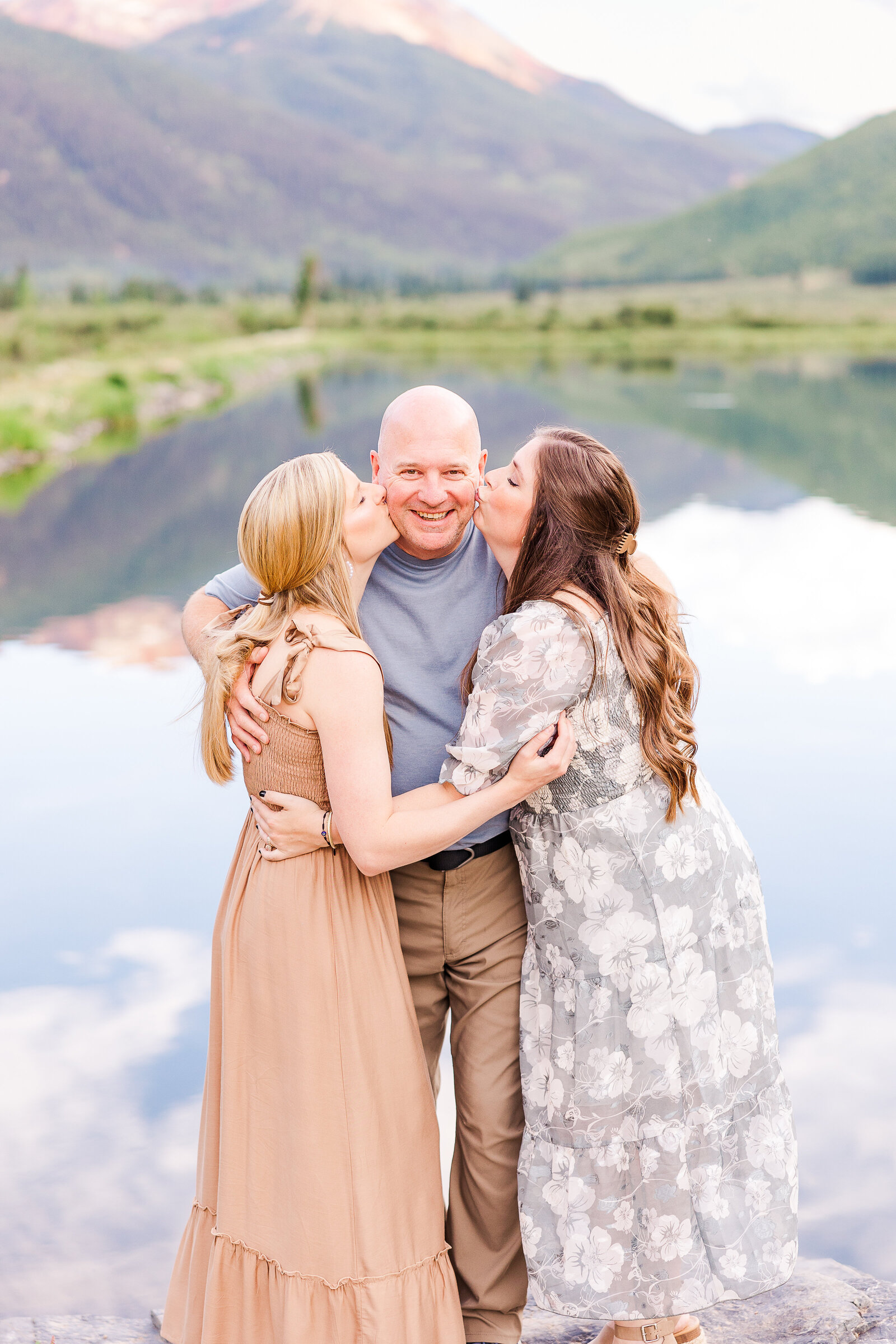daughters give dad a kiss on the cheek