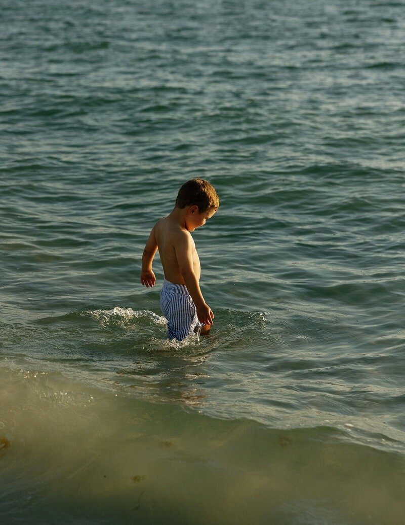 little boy playing in the ocean taken by family photographer naples fl