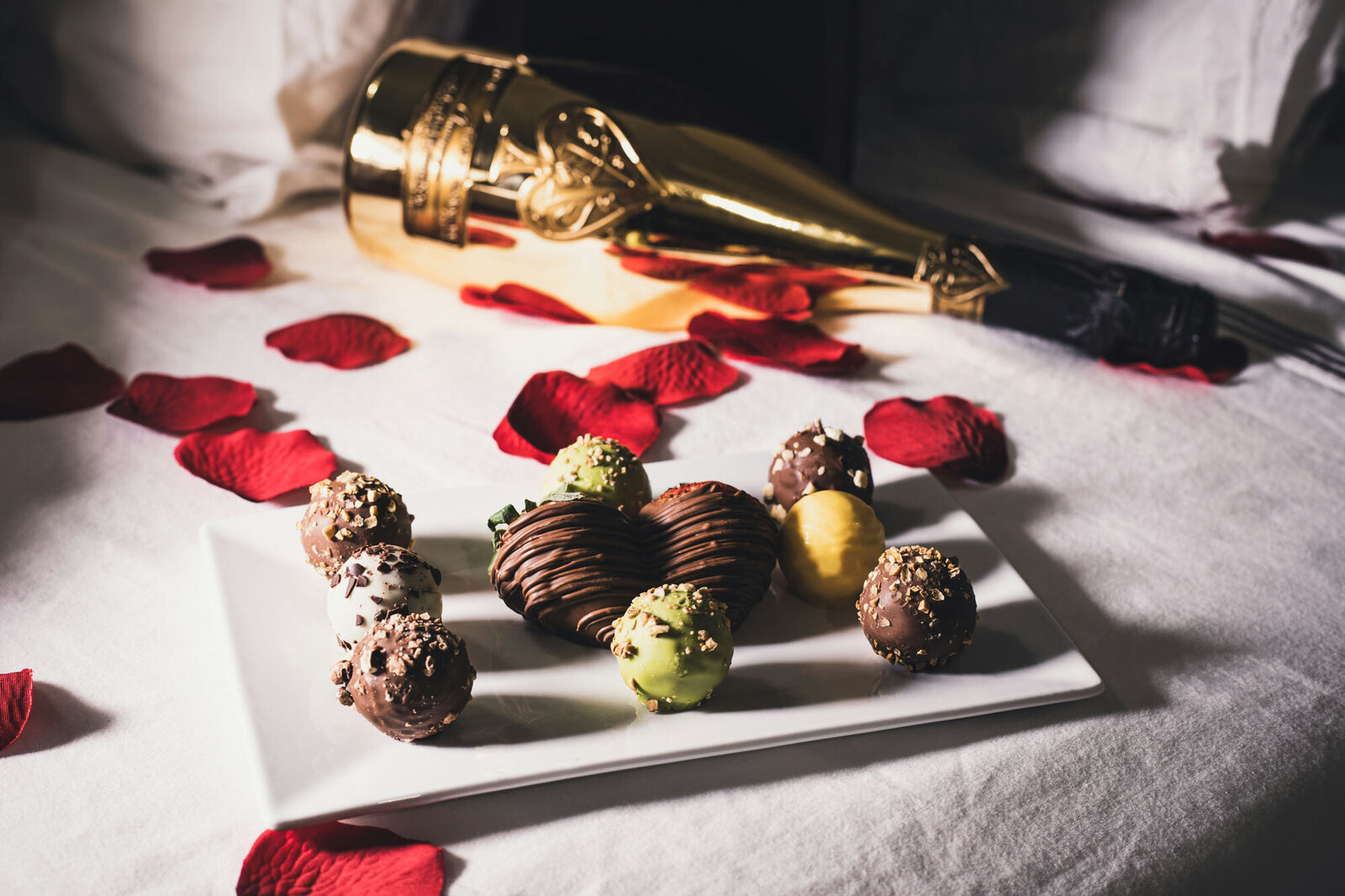 plate of chocolates with a bottle of champagne in the background