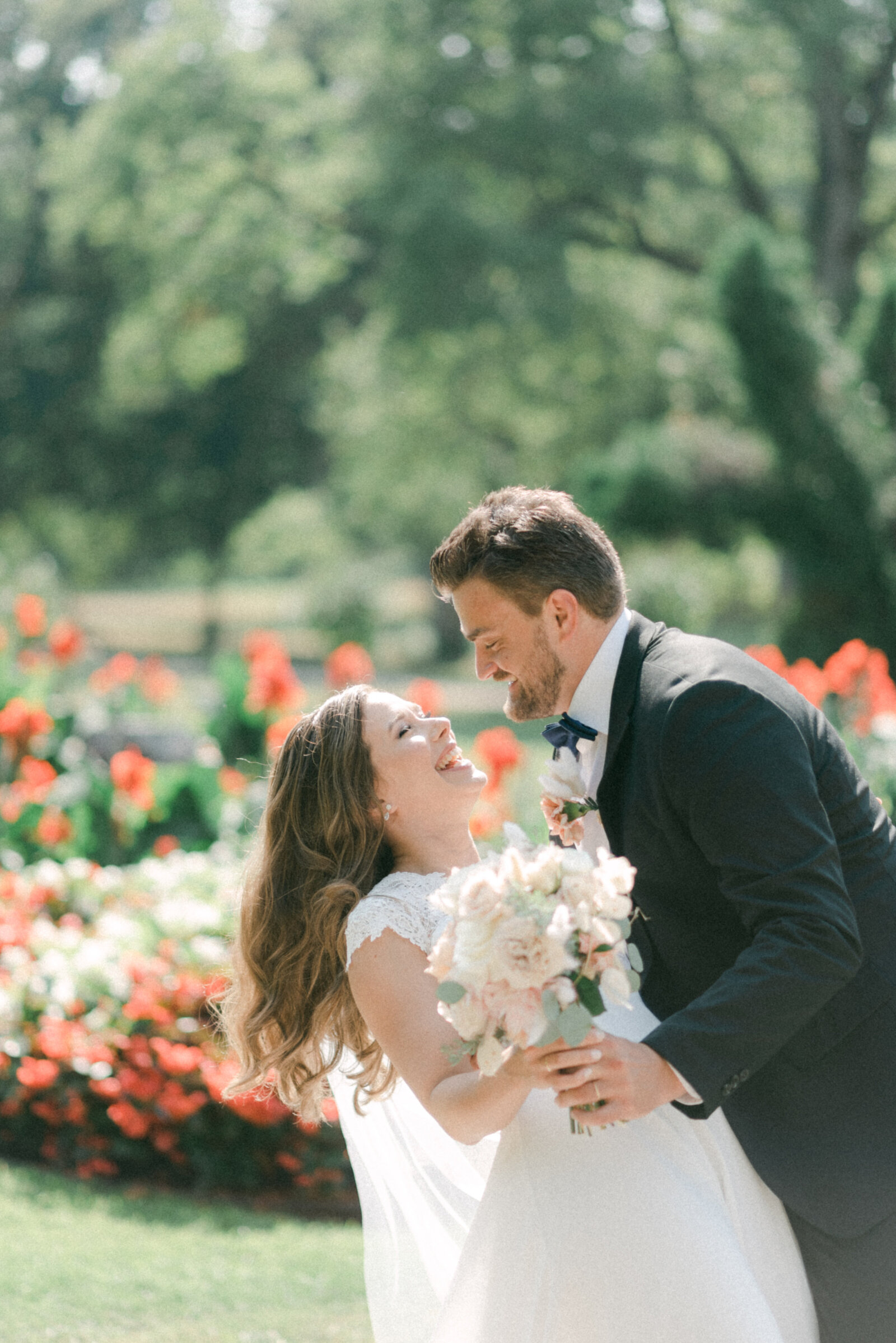 A wedding couple hugging and laughing in the garden during their wedding photo shoot with photographer Hannika Gabrielsson.