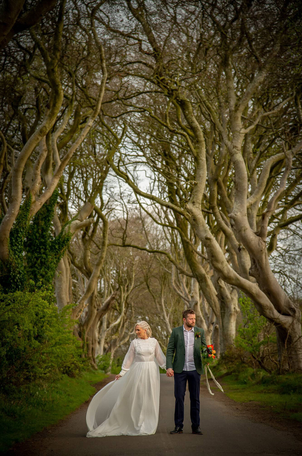 bride and groom along path with towering beeches