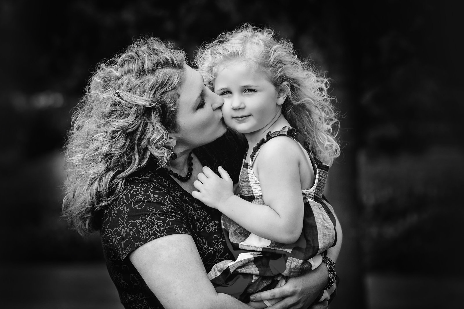 Mommy gives her little girl a kiss