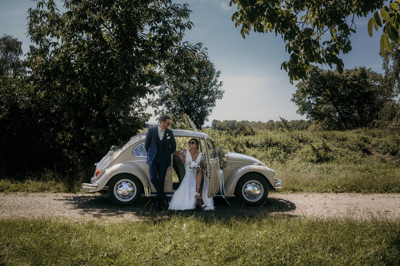 Das Foto vom Paarshooting zeigt das Hochzeitspaar an ihrem Hochzeitsauto.
