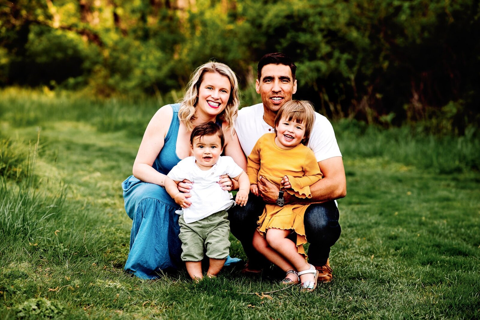 family sitting in a field for a family  photoshoot
