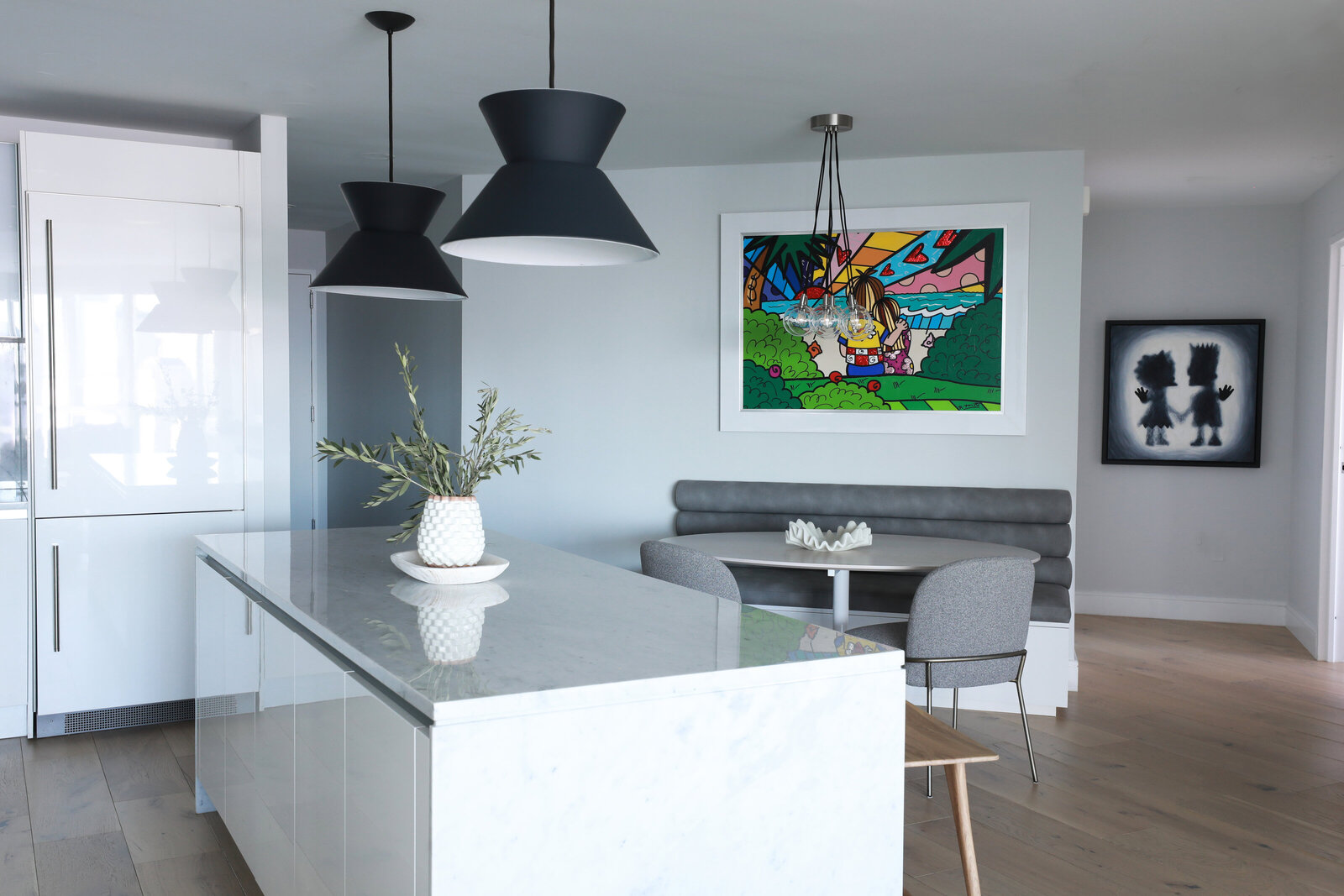 KITCHEN WITH BUILT IN BANQUETTE AND OVAL TABLE FUN ART