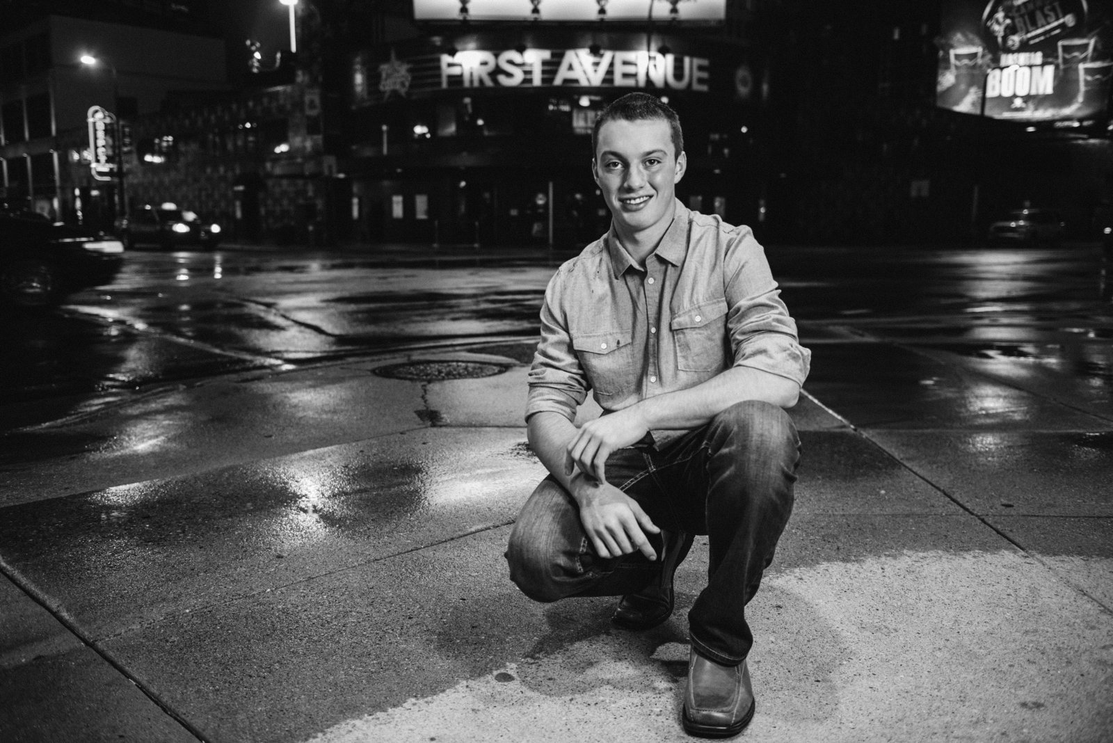 Senior boy sitting in front of First Avenue in Minneapolis, Minnesota