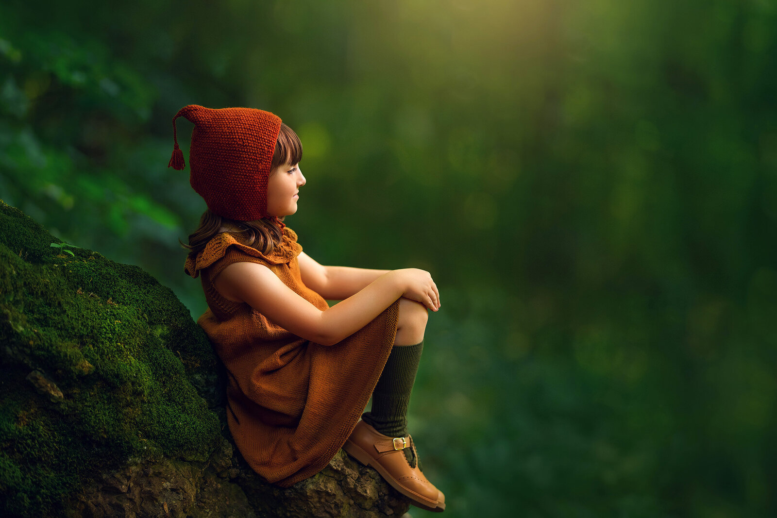 Ethereal portrait of a 6-year-old girl dressed in bespoke knit garments from children clothing company Miou. She is seated on a rock at Ledge Park in Horicon, Wisconsin.