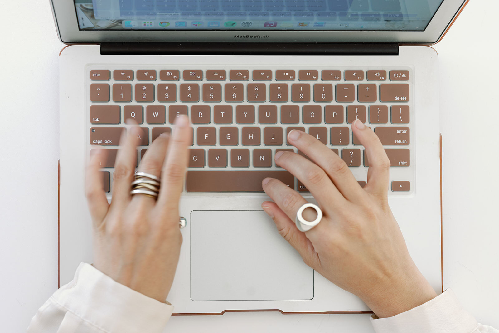 Focus on hands typing on a laptop keyboard, showcasing efficiency and modern work culture.