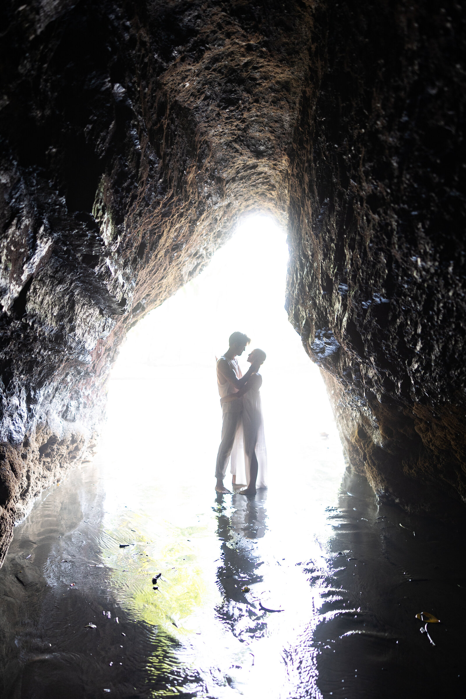 couple embraces in a silhouette cave image