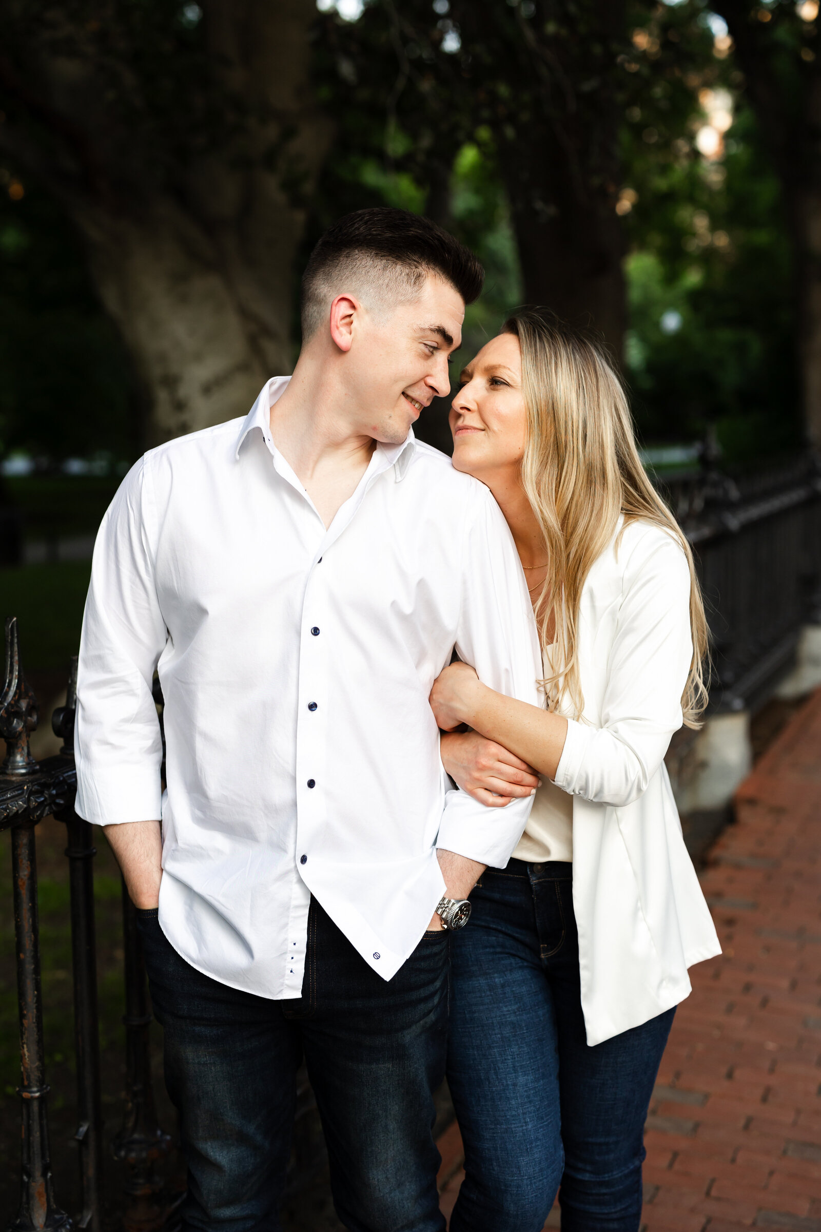 Bride and groom snuggle tight and look at each other during engagement session in downtown Boston, Massachusetts