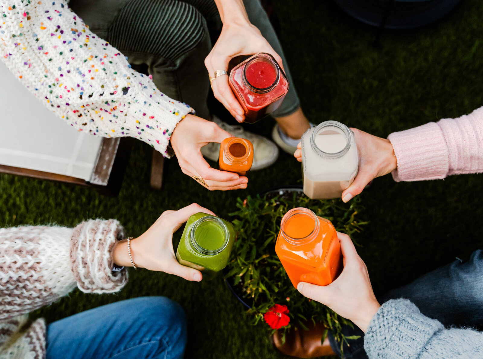 Branding Photographer,  five hands hold different juices and reach in for a "cheers!"