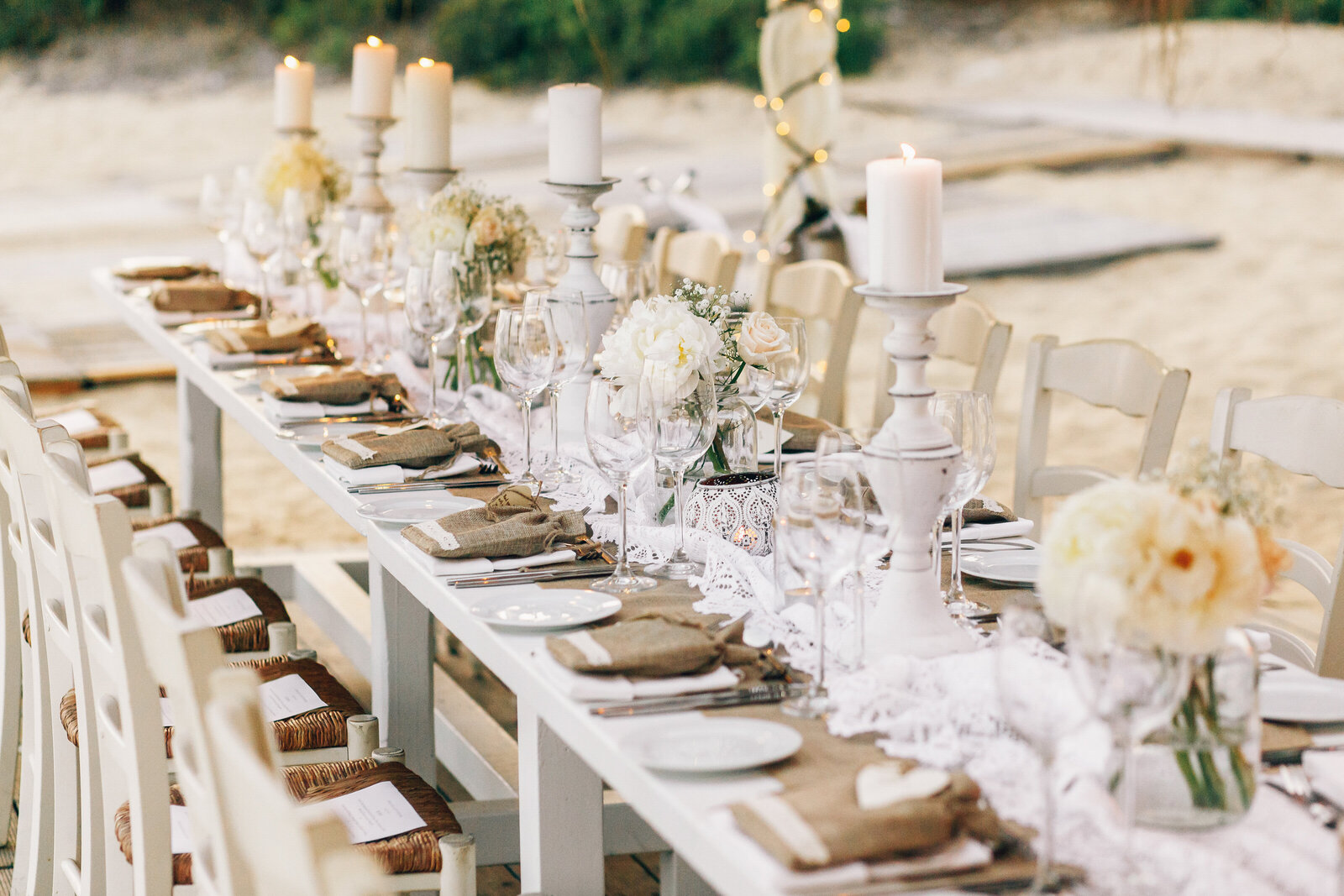 long-dinner-table-decorated-with-flaxen-cloth-white-candles