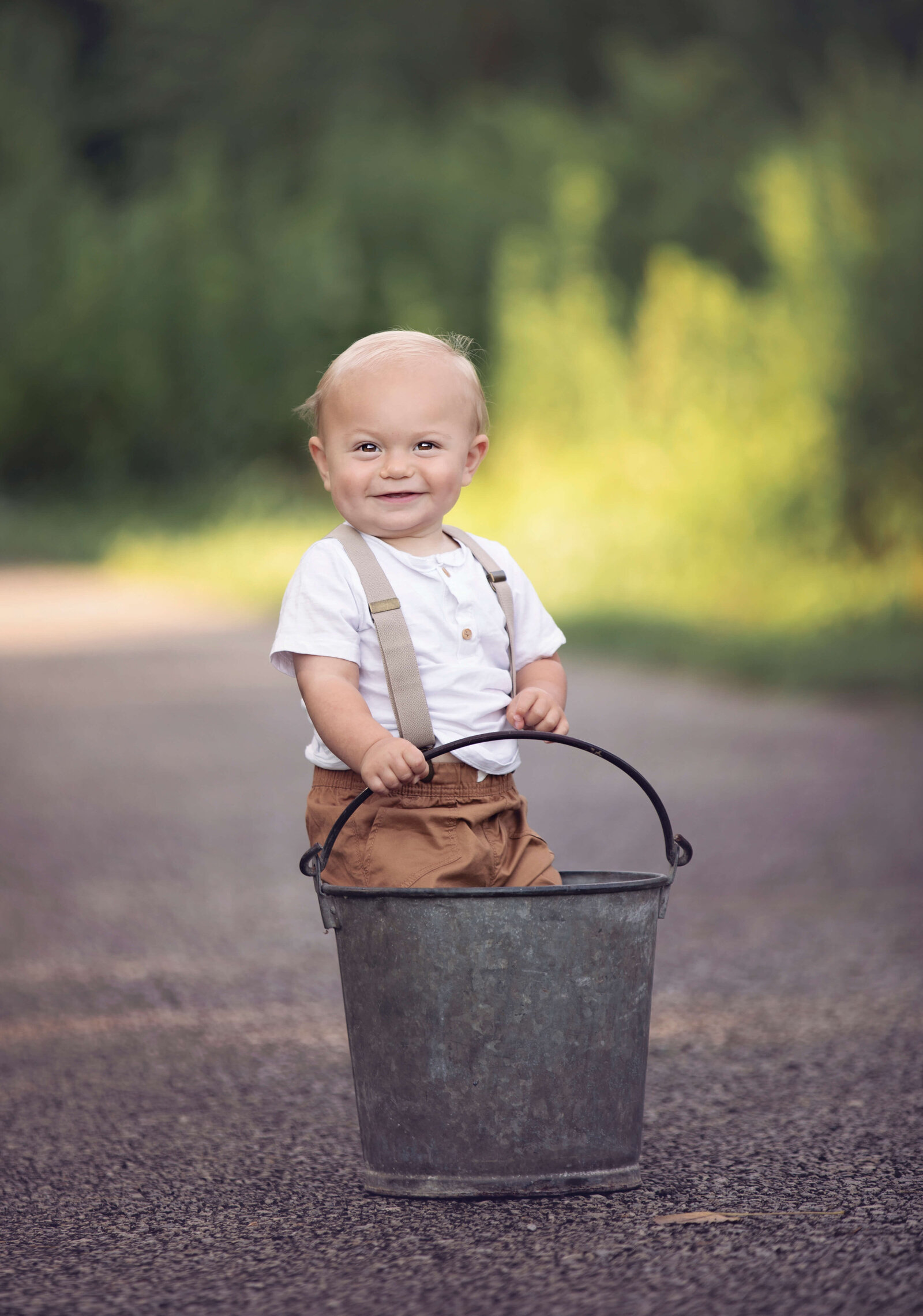 Photo of a little boy standing in a vintage bucket at a park in Erie Pa