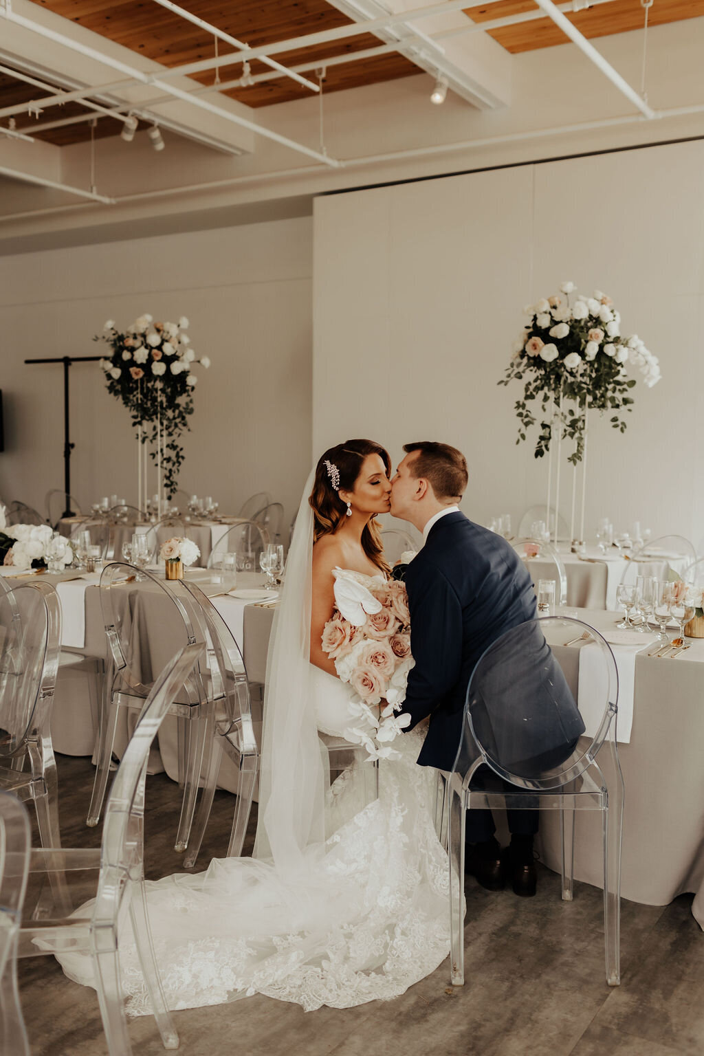 Bride and groom kissing in reception banquet hall