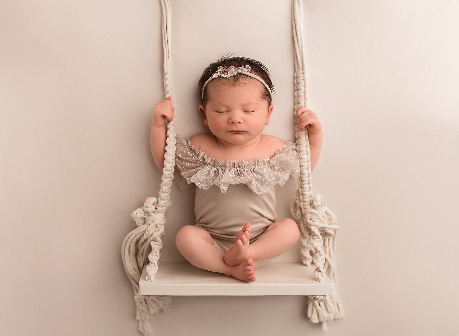 newborn posed on swing in outfit